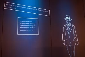 Foto de uma parece onde há frases e a ilustração de Fernando Pessoa